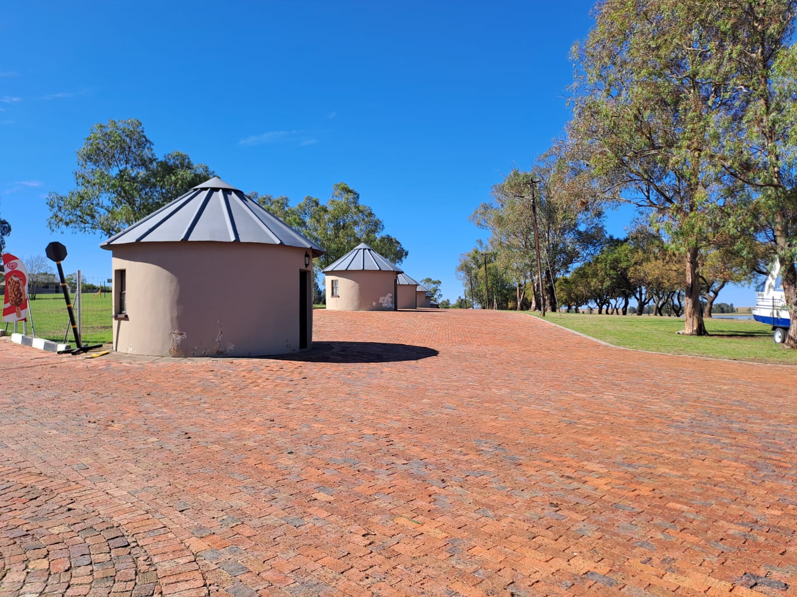 Round resort buildings and brick pathways beneath a blue sky