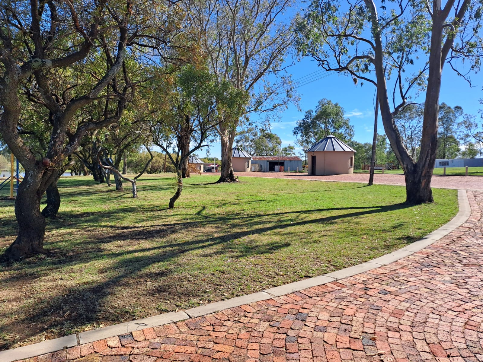 Tree-lined resort grounds with brick pathways and open lawns
