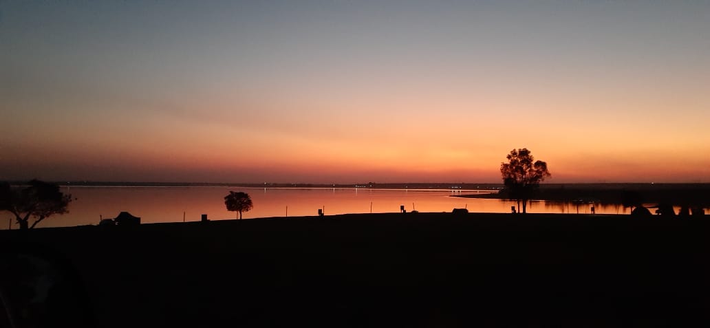 Orange twilight settling over the still dam