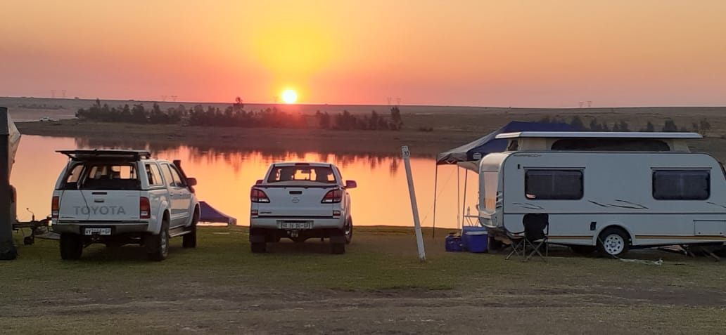Caravan pitched near the dam as the sun sets